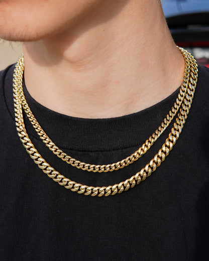 Gold chain necklace on a person wearing a black shirt